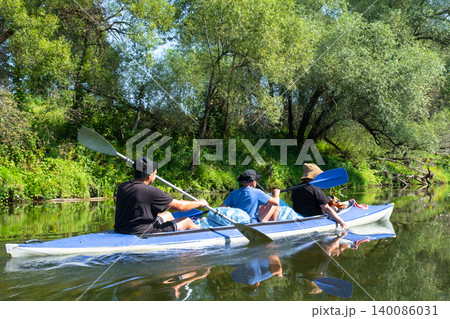 Family in the Vuoksa kayak paddling a summer river route, teamwork, outdoor recreation with child and fun nature tourism. 140086031