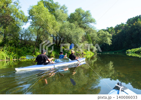 Family in the Vuoksa kayak enjoying a peaceful river paddle, harmony, tradition, and healthy active lifestyle for everyone. 140086033
