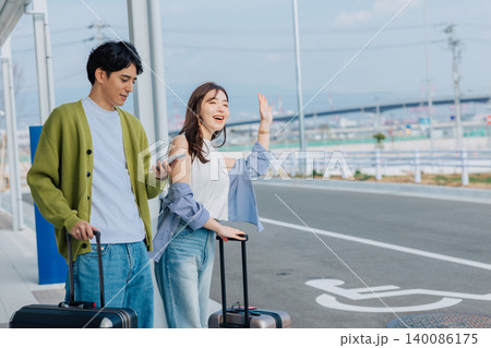 旅先でタクシーを待つカップル　「撮影協力：神戸空港（UKB）」 140086175