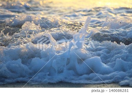 Wave splash at sunset close up. Ocean water in sunlight in motion. Abstract sea background 140086281