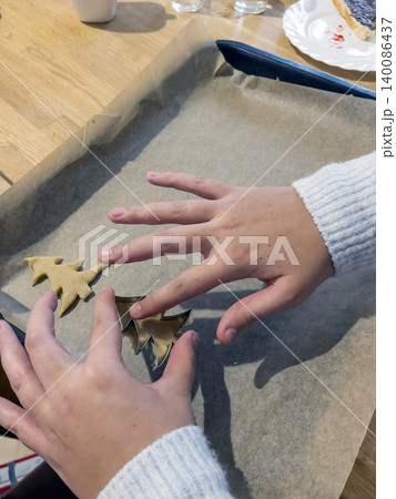 Placing shaped cookie dough onto baking tray Placing shaped cookie dough onto baking tray 140086437