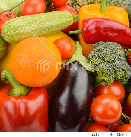 Full frame background of various fresh organic vegetables and fruits including ripe tomatoes, bell peppers, broccoli, eggplant, zucchini, and orange. Full frame background of various fresh organic vegetables and fruits including ripe tomatoes, bell peppers, broccoli, eggplant, zucchini, and orange. 140086561