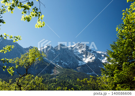 Travel landscape of Zugspitze mountain peak in Alps in Bavaria, Germany, scenic summer nature panorama with forest, snow mountains peak Travel landscape of Zugspitze mountain peak in Alps in Bavaria, Germany, scenic summer nature panorama with forest, snow mountains peak 140086606
