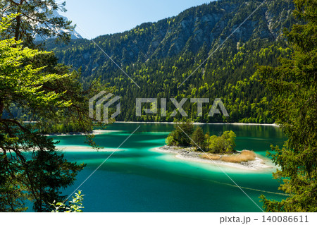 Travel landscape of Eibsee lake in Zugspitze Alps and island in mountains in Bavaria, Germany, scenic summer nature panorama with forest Travel landscape of Eibsee lake in Zugspitze Alps and island in mountains in Bavaria, Germany, scenic summer nature panorama with forest 140086611