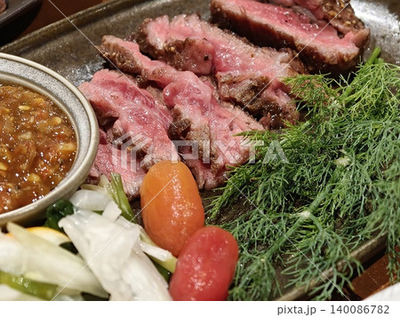 Medium Rare Beef Slices on Tray with Dipping Sauce and Fresh Herbs 140086782