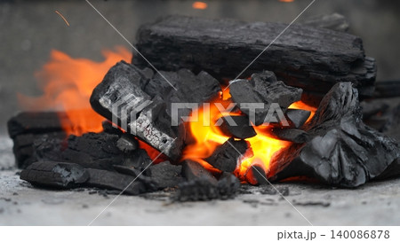 Vibrant Flames Dance on Glowing Charcoal for Grilling 140086878