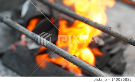 Intense Heat of Grilling Coals with a Blurry Grill Foreground Intense Heat of Grilling Coals with a Blurry Grill Foreground 140086885