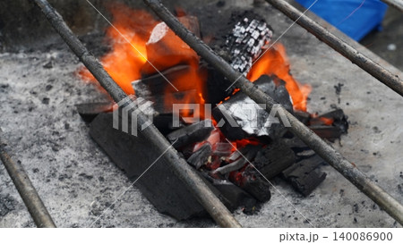 Vibrant Orange Flames on Hot Barbecue Charcoal 140086900