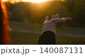 woman hand reaches out sunlight against natural backdrop, expressing freedom, hope and harmony. sunlight reflects inner strength, spiritual awakening and connection with nature. 140087131