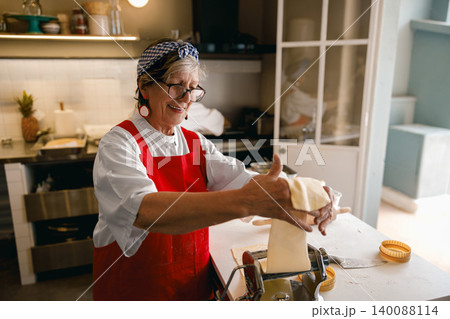 Active Hispanic Senior Woman Making Homemade Pasta in Professional Kitchen Studio 140088114