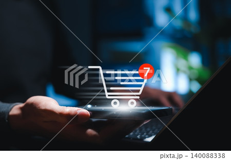 Online shopping cart and e-commerce purchase concept. Person using smartphone and laptop with cart icon, item notification, mobile checkout, digital retail, order process, and online buying experience Online shopping cart and e-commerce purchase concept. Person using smartphone and laptop with cart icon, item notification, mobile checkout, digital retail, order process, and online buying experience 140088338