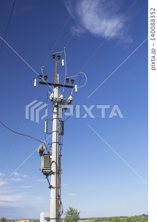 Electricity pole with power lines and transformer against blue sky. Electricity pole with power lines and insulators. Electricity pole with power lines and transformer against blue sky. Electricity pole with power lines and insulators. 140088352