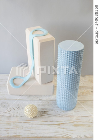 Equipment for yoga and pilates. Yoga blocks, roller, expander and massage ball on a wooden surface. Equipment for yoga and pilates. Yoga blocks, roller, expander and massage ball on a wooden surface. 140088369