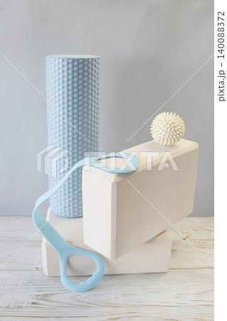 Equipment for yoga and pilates. Yoga blocks, roller, expander and massage ball on a wooden surface. Equipment for yoga and pilates. Yoga blocks, roller, expander and massage ball on a wooden surface. 140088372