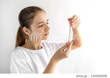 Teen girl examining a test tube in a home science experiment with focused expression Teen girl examining a test tube in a home science experiment with focused expression 140088606