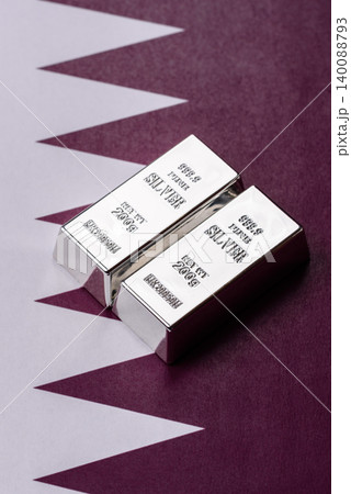 A silver bar, white metal against a backdrop of Qatari money, as a concept. A silver bar A silver bar, white metal against a backdrop of Qatari money, as a concept. A silver bar 140088793