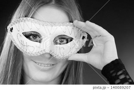 Woman holding carnival mask closeup Woman holding carnival mask closeup 140089207