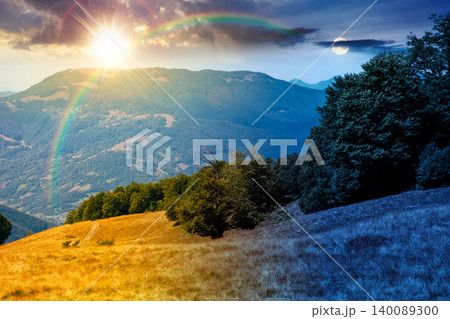 carpathian mountain landscape in summer. day meet night. primeval beech forest on the grassy hill. sun and moon over epic scenery of ukrainian highlands. pristine ecosystem of europe for wallpaper 140089300