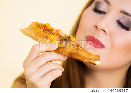 Woman eating hot pizza slice 140089317