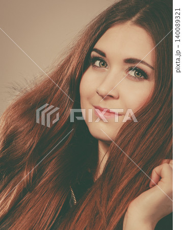 Happy woman wearing dark poncho coat with hood 140089321