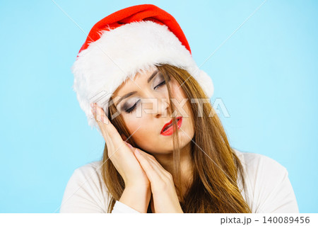 Woman in santa hat being sleepy Woman in santa hat being sleepy 140089456