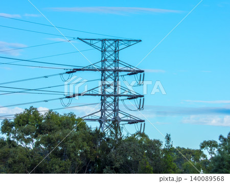 A large electricity transmission tower surrounded by trees on a hill A large electricity transmission tower surrounded by trees on a hill 140089568
