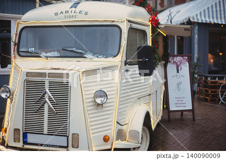 Vintage light yellow van converted into a mobile cider bar and decorated with Christmas lights Vintage light yellow van converted into a mobile cider bar and decorated with Christmas lights 140090009