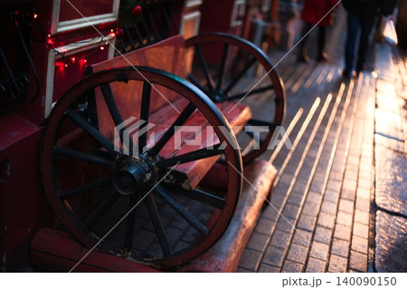 Rustic Wooden Bench with Large Vintage Wagon Wheels on Cobblestone Street Rustic Wooden Bench with Large Vintage Wagon Wheels on Cobblestone Street 140090150