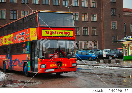Red double-decker sightseeing bus parked on a damp Red double-decker sightseeing bus parked on a damp 140090175