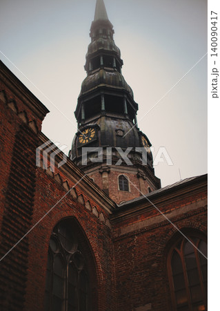 Medieval Church Spire with Clock Tower Rising Above  140090417