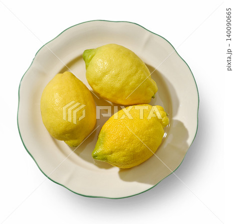 Three Fresh Lemons on a Decorative Ceramic Plate Isolated on White. Top View Three Fresh Lemons on a Decorative Ceramic Plate Isolated on White. Top View 140090665