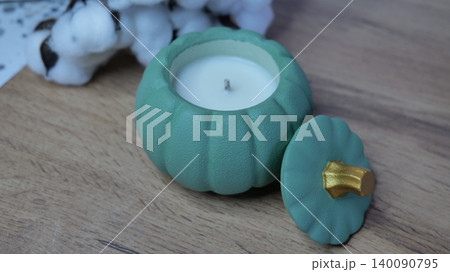Green pumpkin-shaped soy candle, autumn decor, cozy interior Green pumpkin-shaped soy candle, autumn decor, cozy interior 140090795