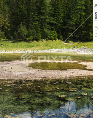 Seasonal emerald alpine lake Gruner See in Styria, Austria, highlighting fragile alpine habitats under environmental stress. 140091170