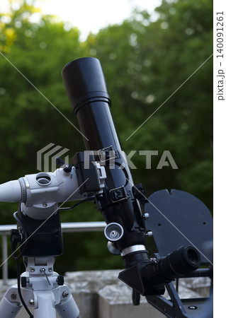Astronomy telescope on a tripod in use outdoors, capturing the experience of amateur stargazing and night sky observation. Astronomy telescope on a tripod in use outdoors, capturing the experience of amateur stargazing and night sky observation. 140091261