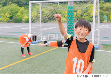 サッカーでゴールを決め笑顔で喜ぶ少年 サッカーでゴールを決め笑顔で喜ぶ少年 140091608