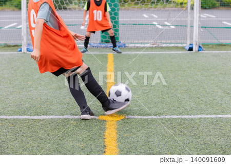 サッカーでシュートをする少年選手とゴールキーパー 140091609