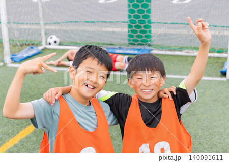 サッカーでゴールを決め笑顔で肩を組む少年たち サッカーでゴールを決め笑顔で肩を組む少年たち 140091611