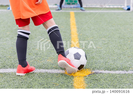 サッカーでシュートをする男性 140091616