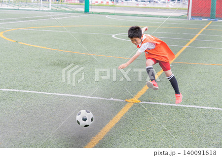サッカーでシュートを打つ少年 140091618