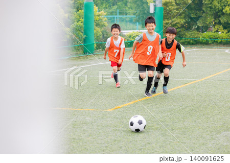 ボールを追いかけて走るサッカー少年たち 140091625