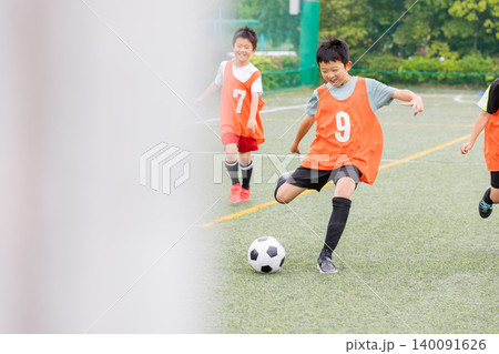 ドリブルの後シュートでゴールを狙うサッカー少年たち 140091626