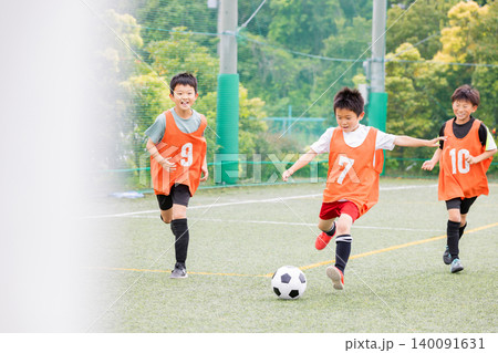 ドリブルの後シュートでゴールを狙うサッカー少年たち 140091631