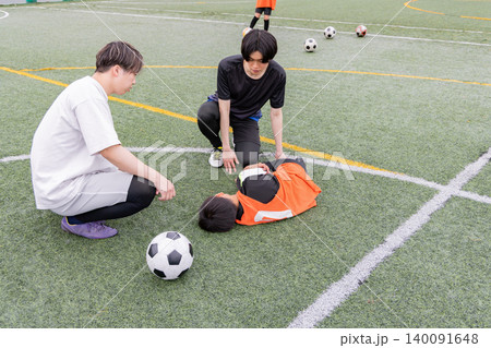 怪我をした少年サッカー選手をサポートするコーチたち 怪我をした少年サッカー選手をサポートするコーチたち 140091648