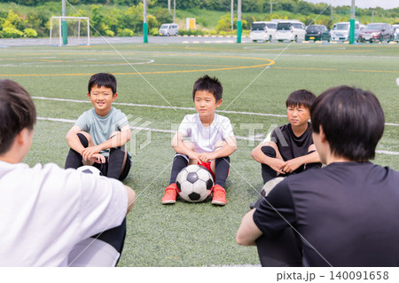 サッカーコーチと円陣ミーティングをする少年たち サッカーコーチと円陣ミーティングをする少年たち 140091658
