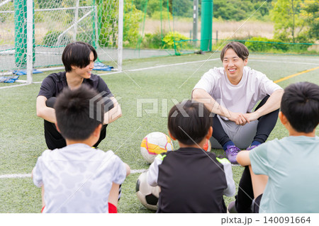 サッカーコーチと円陣ミーティングをする少年たち サッカーコーチと円陣ミーティングをする少年たち 140091664