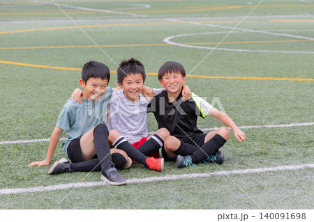サッカーボールを囲んで笑顔を見せる少年たち 140091698