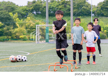 フットサル練習でラダートレーニングを行う少年たちと男性コーチ 140091714