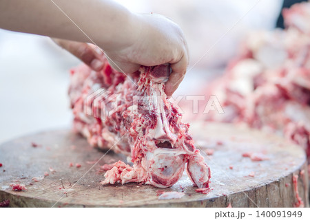 cutting meat on a kitchen table cutting meat on a kitchen table 140091949