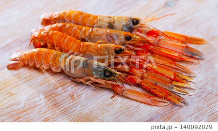 Raw Norway lobster on wooden table Raw Norway lobster on wooden table 140092029