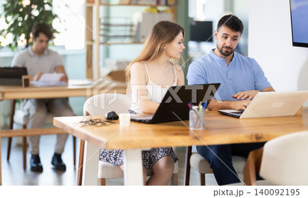 Girl helps guy complete task on laptop 140092195